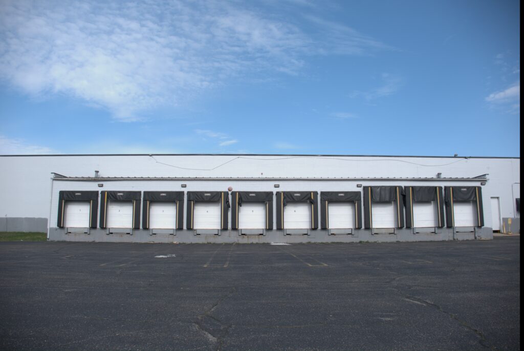 Industrial facility exterior with multiple loading dock doors, showcasing WGS Global Services' logistics capabilities in the Midwest.